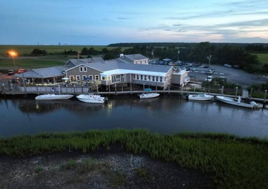 Aerial view of the waterfront restaurant at twilight with boats along the docks